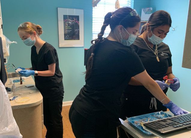 students working with dental tools in class